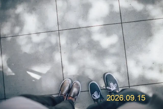 Photo of shoes on pavement with a yellow 2026.09.15 date stamp